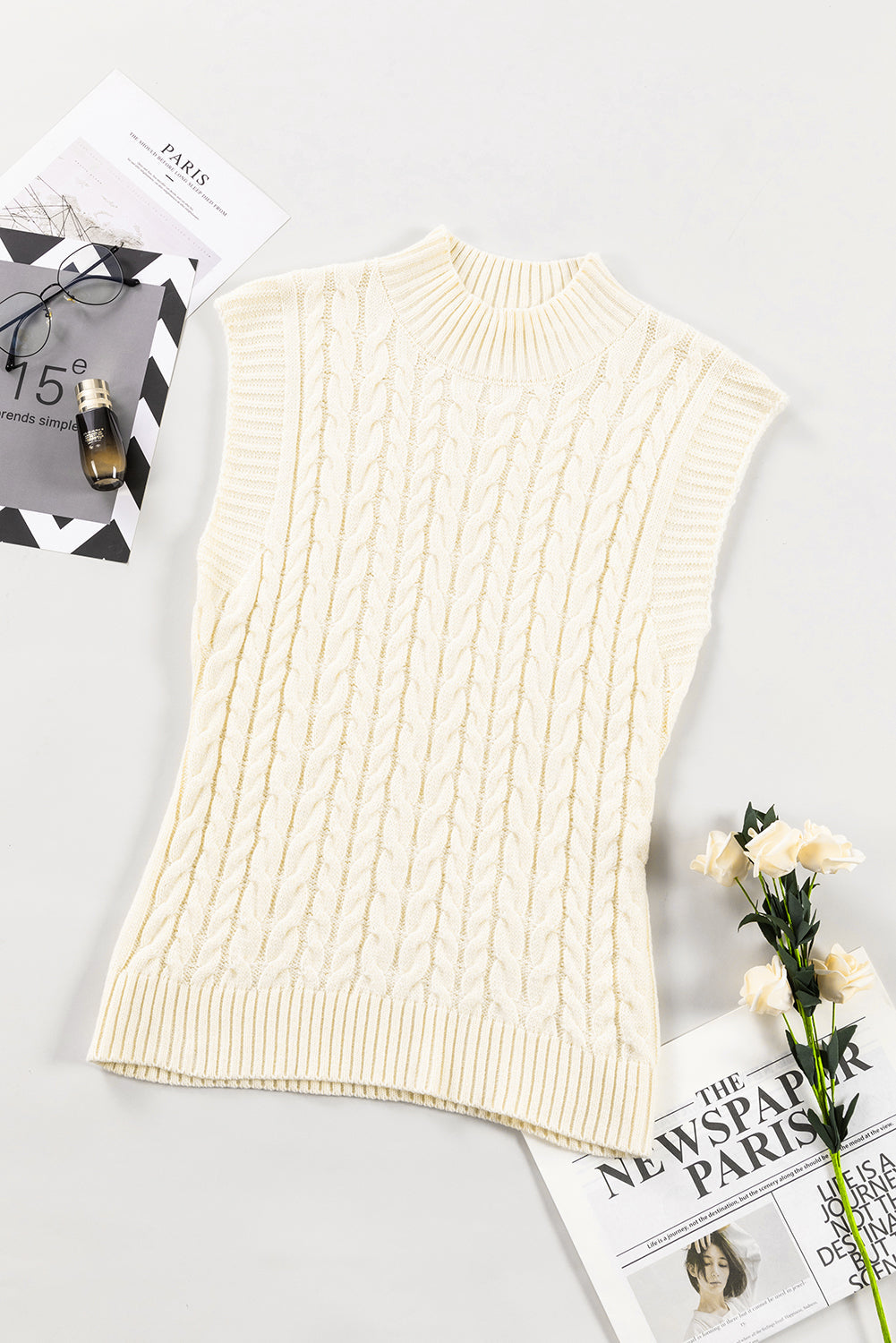 Ivory cable knit mock neck vest with chunky texture and ribbed trim.