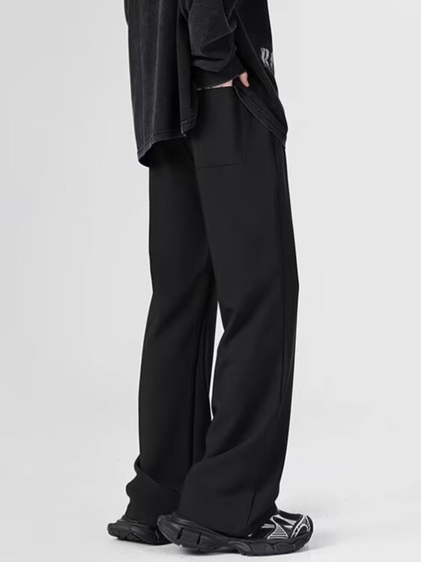 Black relaxed fit sweatpants with pockets, shown on a man.