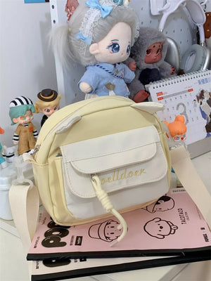 Yellow mini crossbody bag with cat ears and front pocket with embroidery.