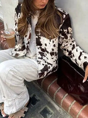 Buttoned collared jacket in cow print with button front closure.