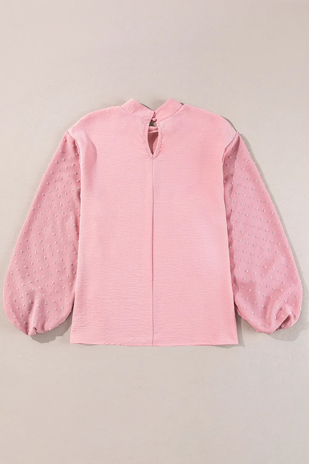 Blush pink blouson top with textured fabric and Swiss dot balloon sleeves.
