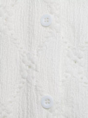 White lace-trimmed button-up maternity shirt with textured fabric and ruffle sleeves.
