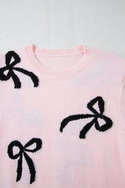 Pink knit crewneck sweater with black bow motifs and ribbed neckline.