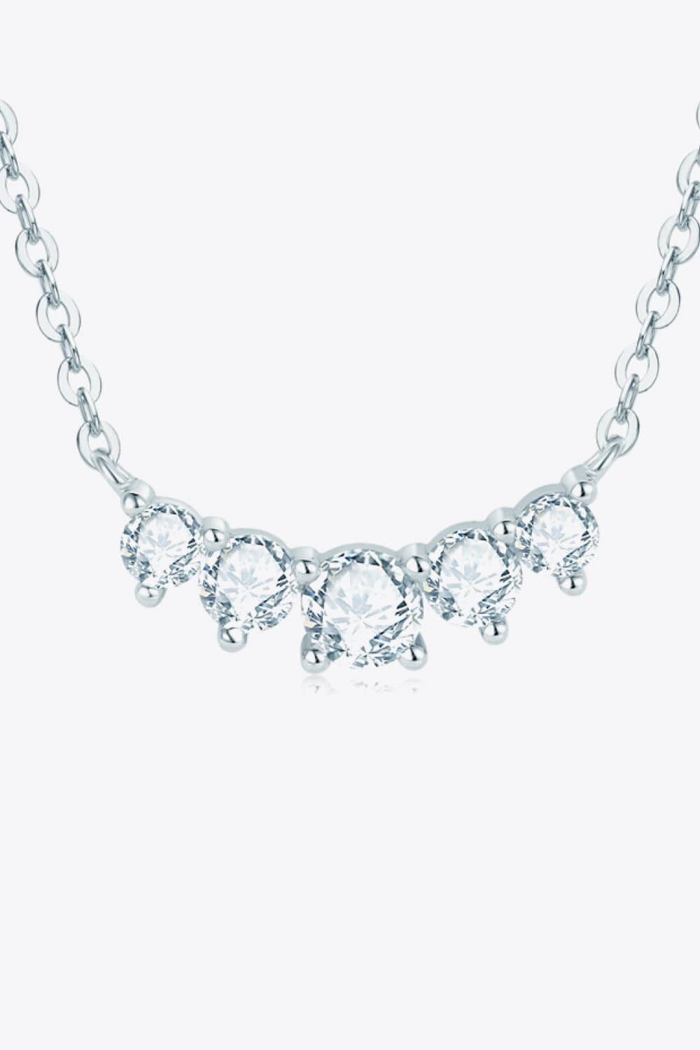 Celestial Arc Necklace in silver with five clear round gemstones on a delicate chain.