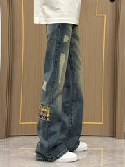 Distressed blue wash wide-leg jeans with patchwork detail and frayed accents.
