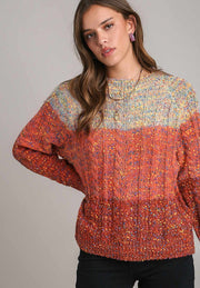 Ombre cable knit crewneck pullover sweater in orange-red with textured yarn and crew neckline.