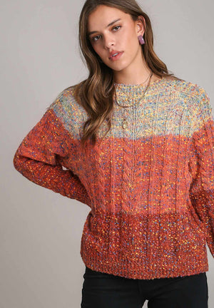 Ombre cable knit crewneck pullover sweater in orange-red with textured yarn and crew neckline.