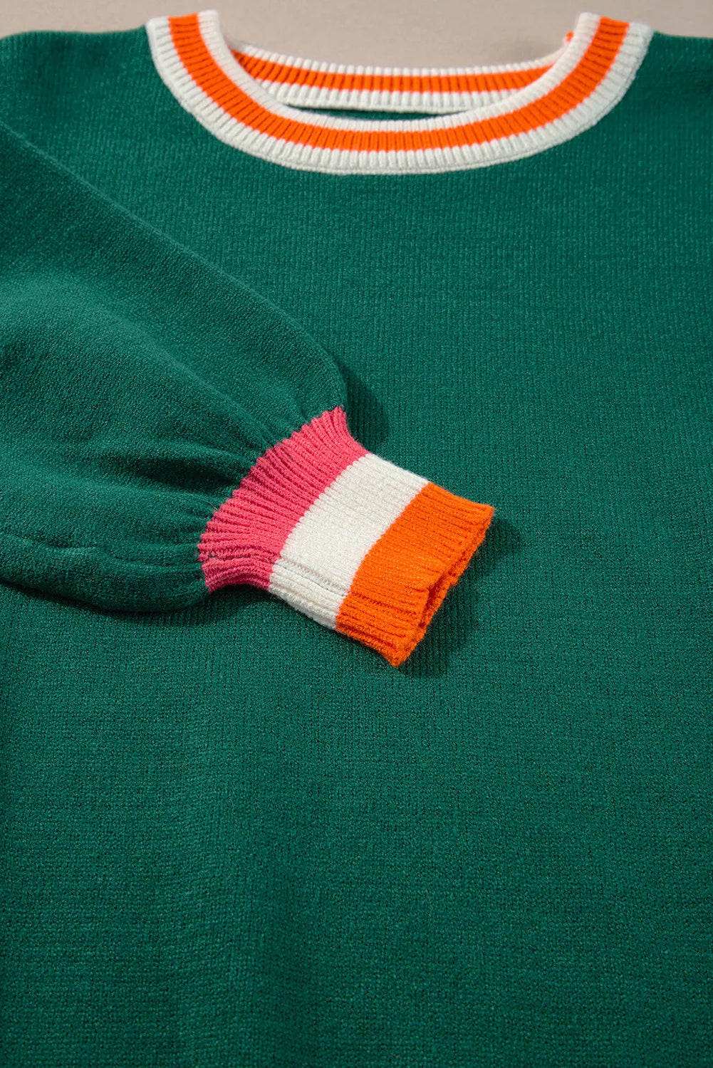 Dark green knit sweater with balloon sleeves and colorblock trim on neckline and cuffs.