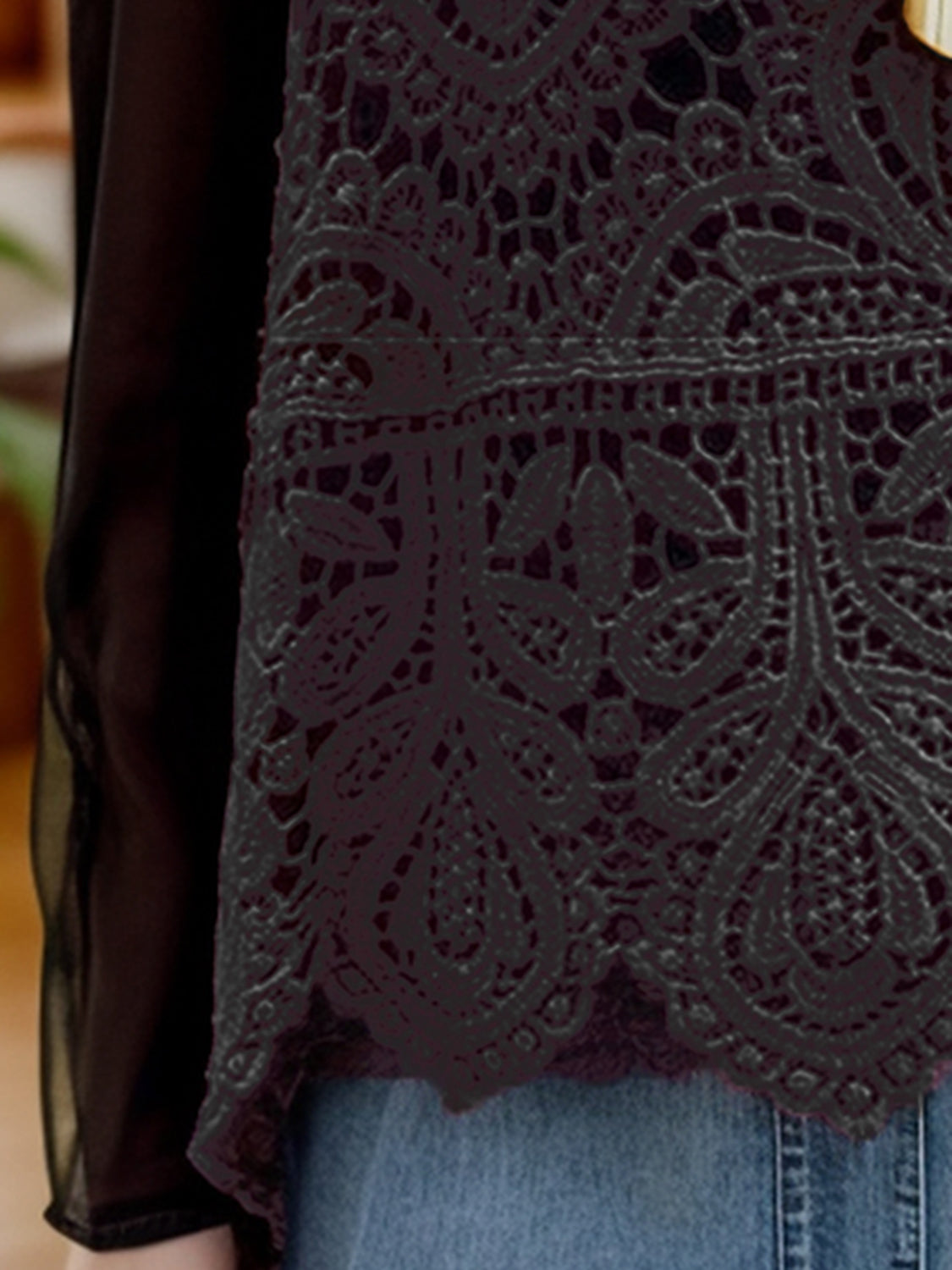 Lace overlay cropped vest in deep purple with intricate floral pattern and sheer sleeves.