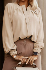 Khaki pleated yoke blouse with button detail and elastic cuffs.