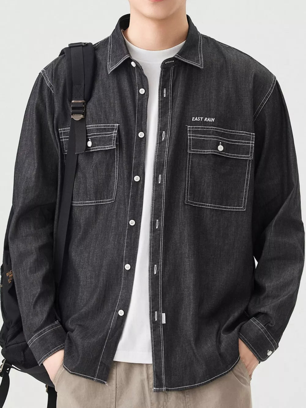 Black denim button-up shirt with white contrast stitching and chest pockets.