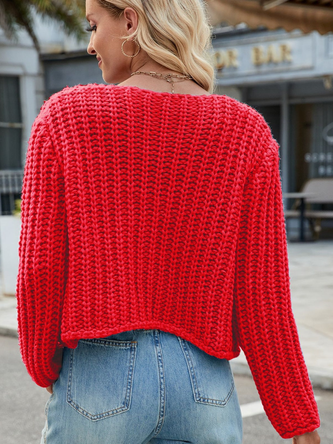 Chunky knit red acrylic cardigan with gold buttons and pockets.