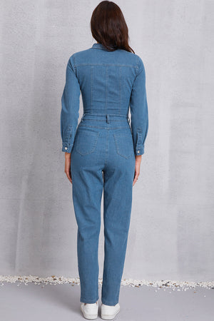 Denim utility jumpsuit in medium wash with defined waist and button cuffs.