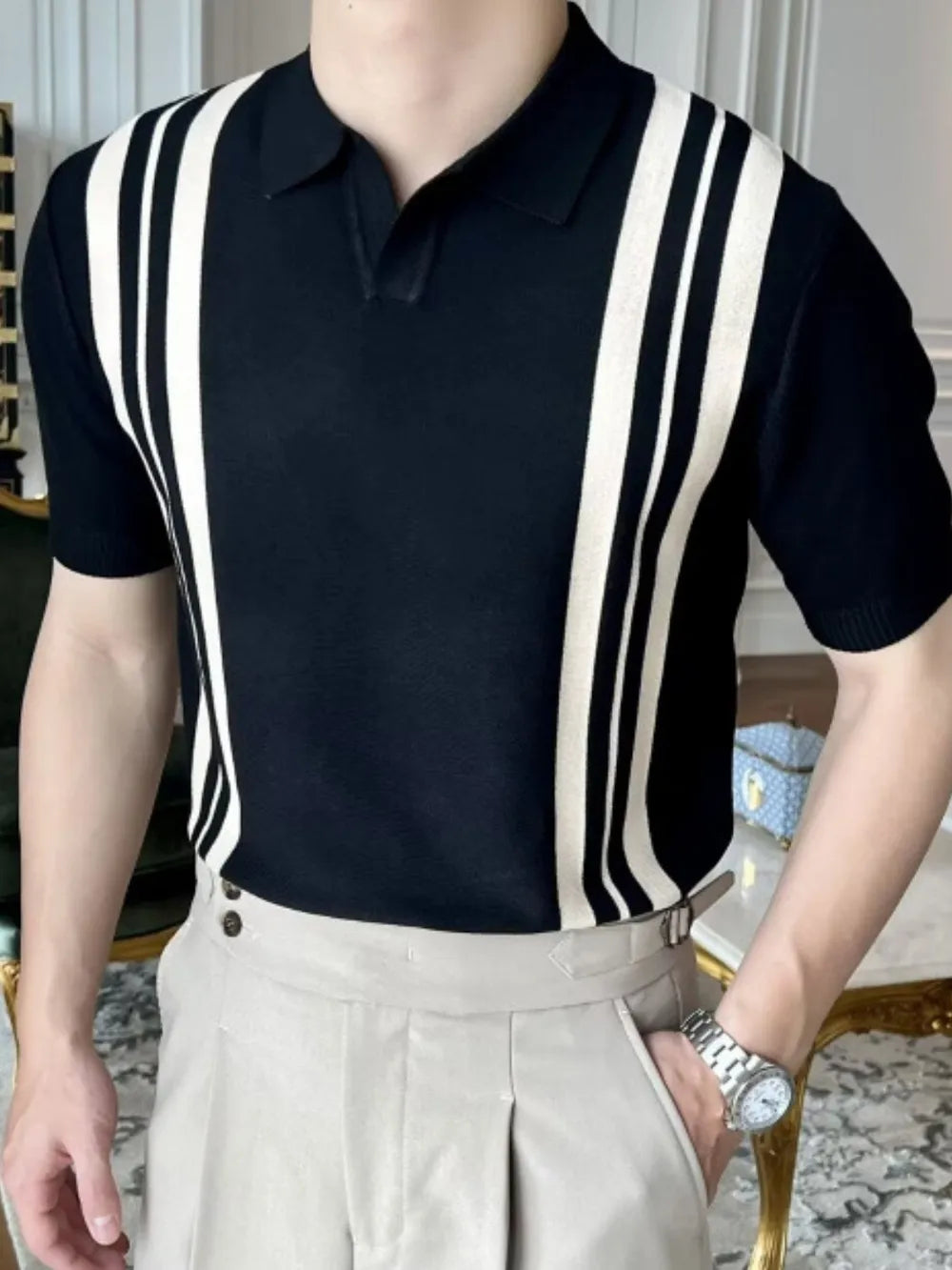Black knit polo shirt with ivory vertical stripes, short sleeves, and collar.
