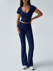 Dark blue ruched waistband flared lounge pants and a matching twist-front v-neck cropped top.