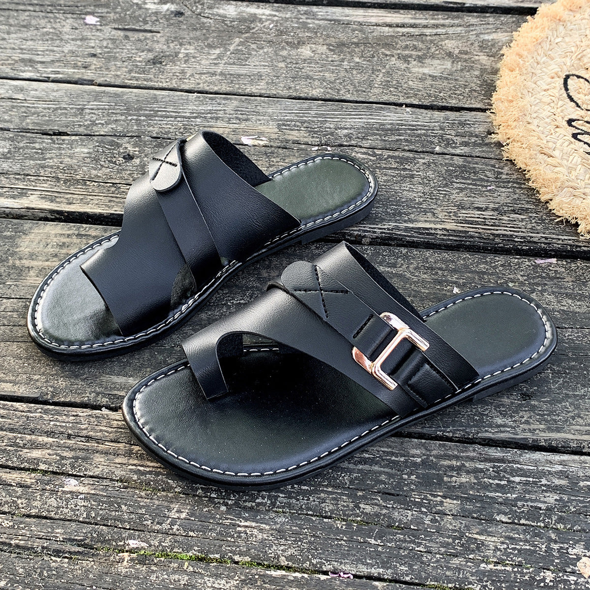 Black leather toe loop flat sandals with buckle detail and contrast stitching.