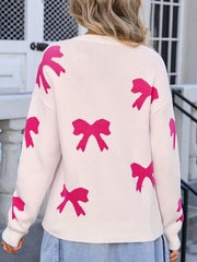 Cream knit sweater with allover pink bow motif, crew neck, long sleeves.
