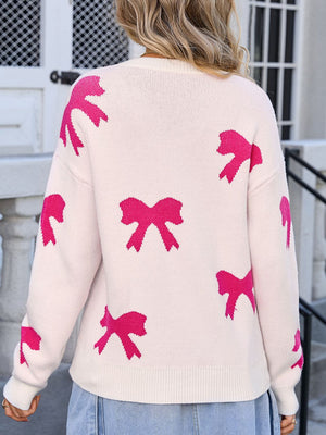 Cream knit sweater with allover pink bow motif, crew neck, long sleeves.