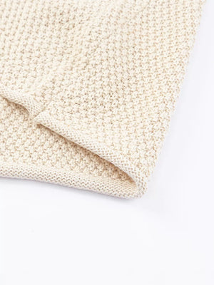 Beige knit sweater with textured stitch detail and ribbed hem.