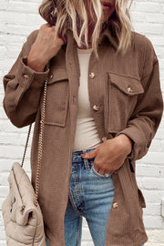 Brown corduroy oversized utility jacket with button-flap chest pockets and button cuffs.