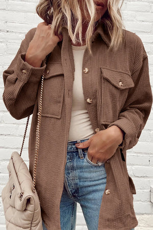Brown corduroy oversized utility jacket with button-flap chest pockets and button cuffs.