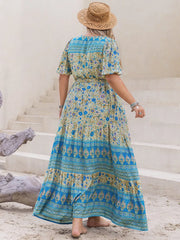 Bohemian floral maxi dress with tie waist, short sleeves, and tiered skirt in blue and yellow.