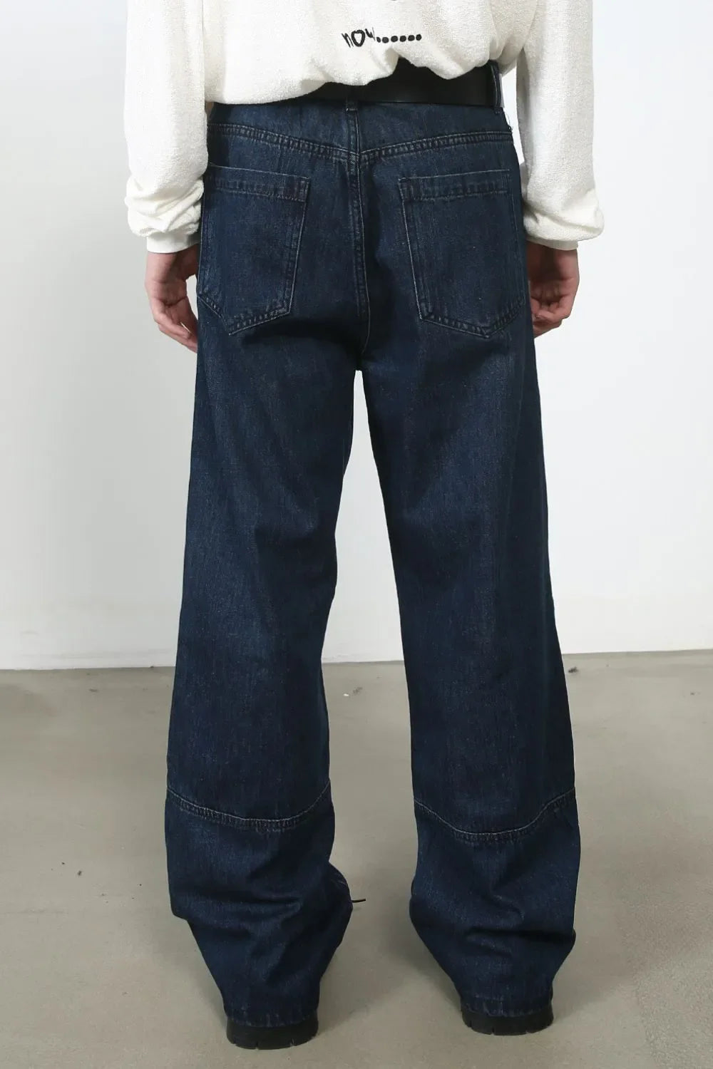 Dark wash denim wide-leg jeans with panel detail and distressed accents.