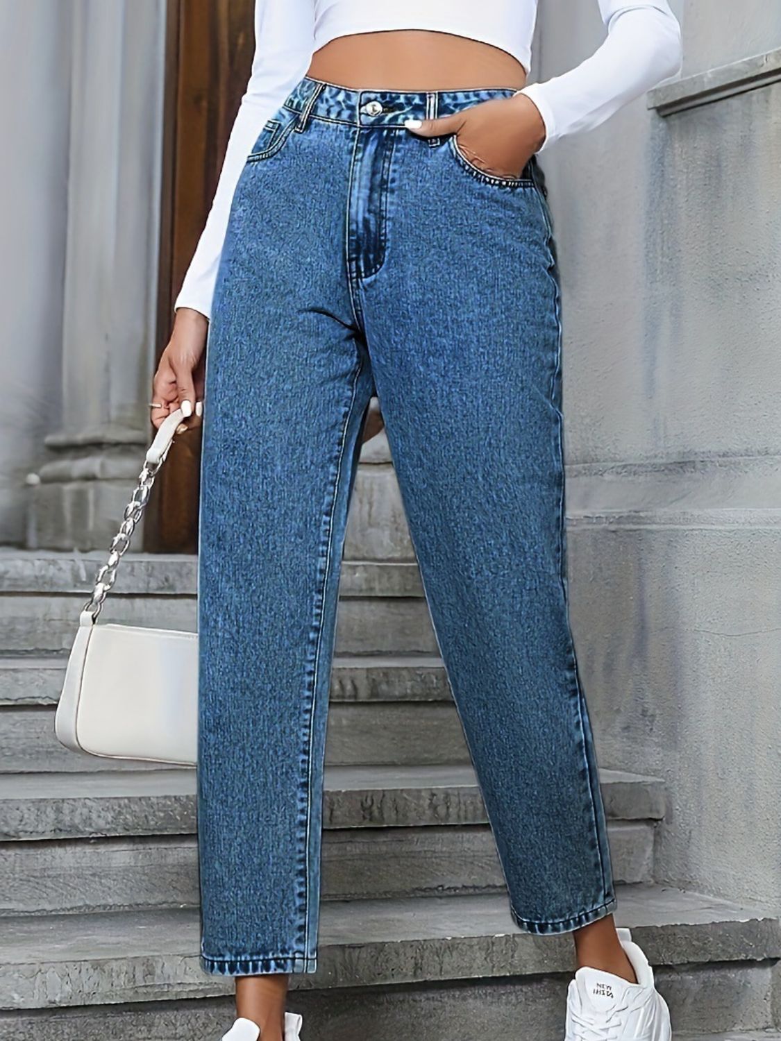Medium wash high-rise denim jeans with a buttoned front and classic fit.