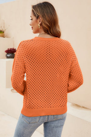 Orange open-knit crewneck sweater with subtle texture and long sleeves.