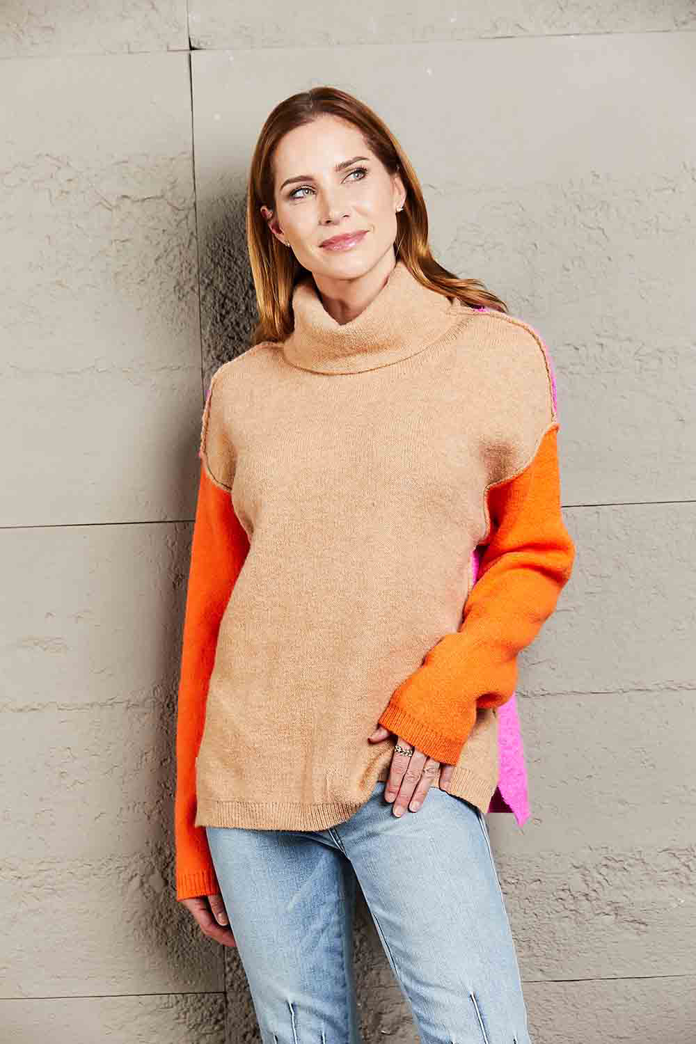 Colorblock turtleneck sweater with asymmetric hem in khaki, rust, orange, and pink.
