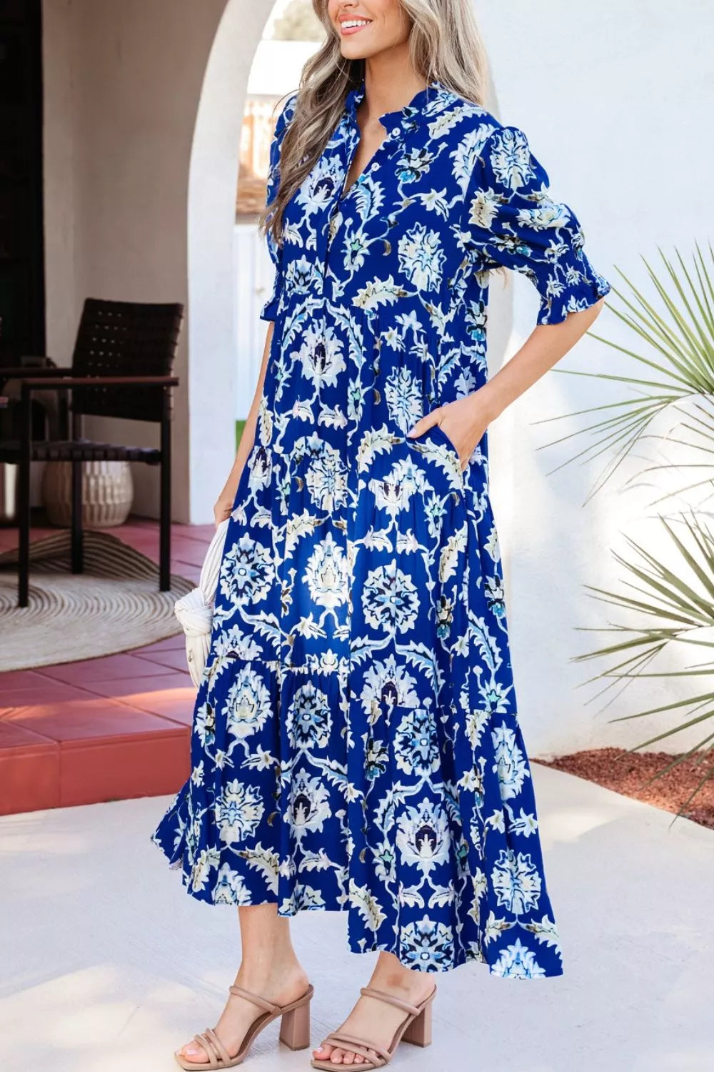 Vibrant floral maxi dress with frilled collar, buttoned front, and pockets.