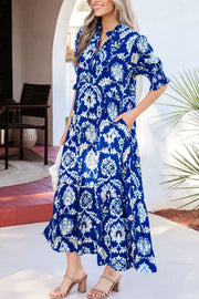Vibrant floral maxi dress with frilled collar, buttoned front, and pockets.
