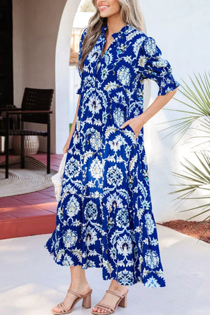 Vibrant floral maxi dress with frilled collar, buttoned front, and pockets.