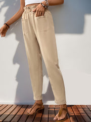 Tan linen blend trousers with gathered waist, pockets, and cuffed hem.