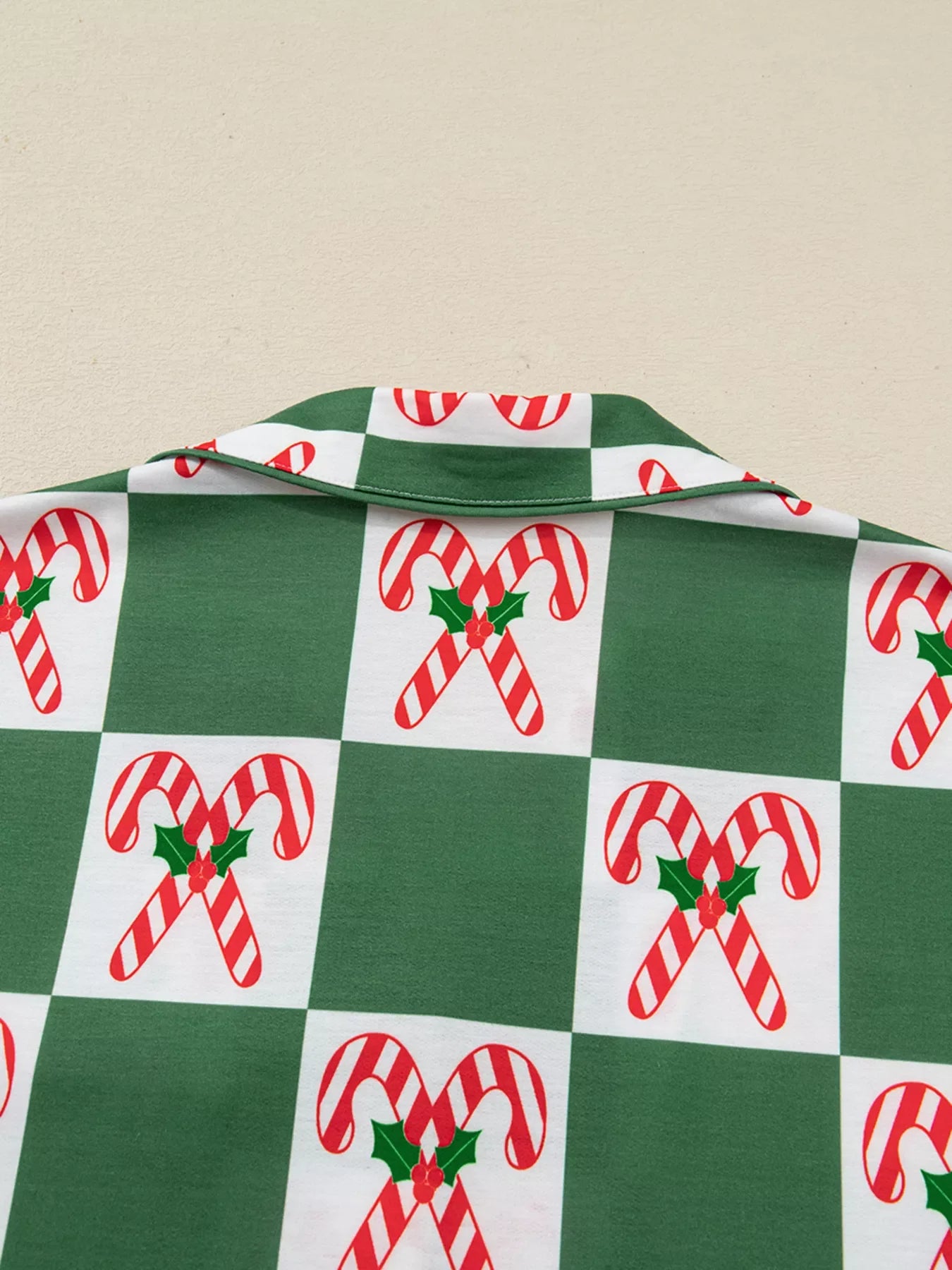 Green pajama set with candy cane checkered print and collar detail.
