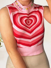 Pink knit tank top with bold red and pink heart intarsia pattern and mock neck.