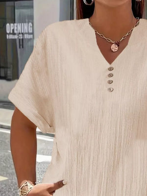 Textured apricot v-neck t-shirt with decorative buttons and short sleeves.