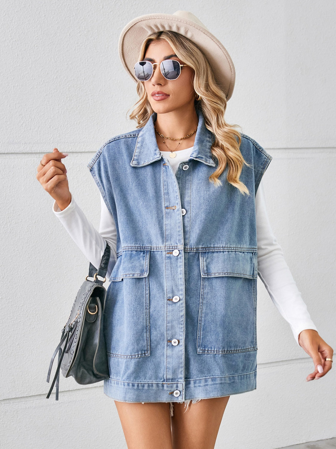 Light blue denim utility vest with button front and four pockets.