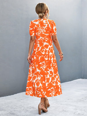 Orange-red floral print midi dress with puff sleeves and tiered skirt.