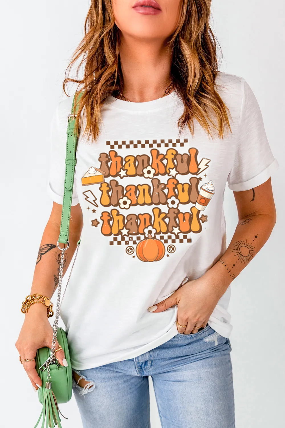 White graphic t-shirt with "thankful" in retro font, pie, pumpkin, and coffee cup graphics.