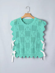 Pointelle knit sweater vest in mint green with scalloped trim and white tie details on sides.
