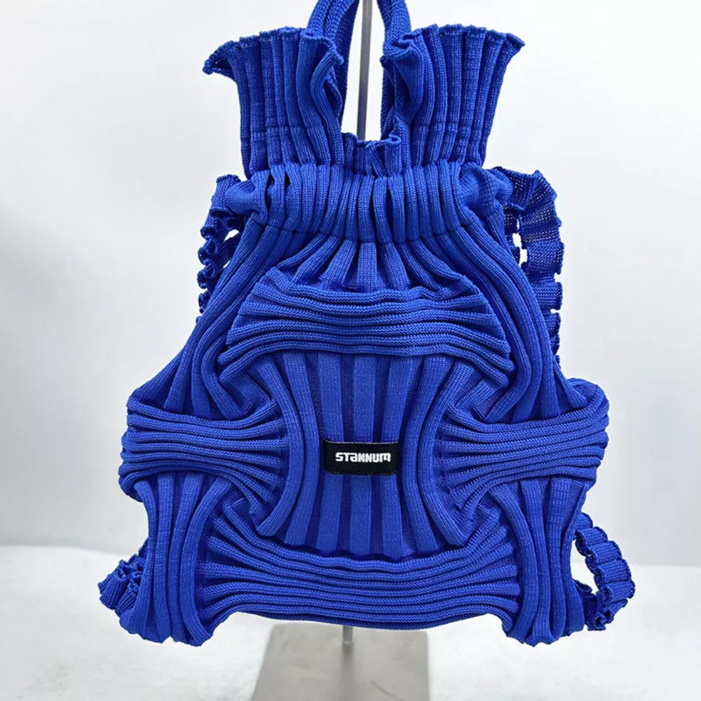 Royal blue textured knit medium backpack with ruched top and woven detail.