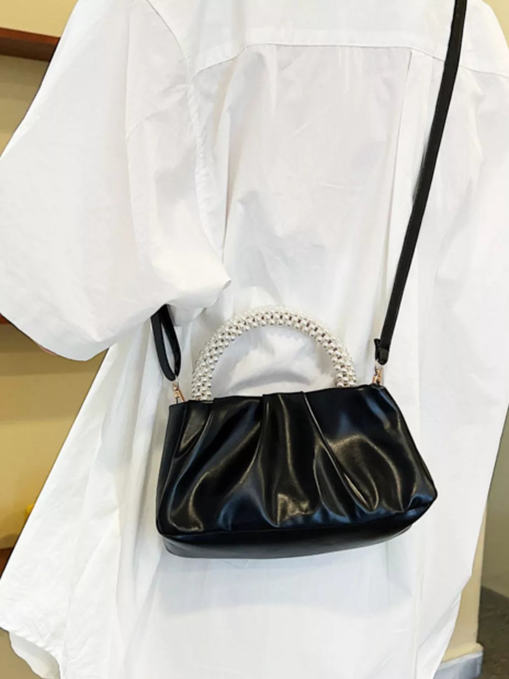 Black ruched crossbody bag with pearl handle and strap