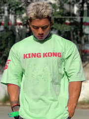 King Kong graphic oversized tee in Gum Leaf green with red text and sleeve detail.
