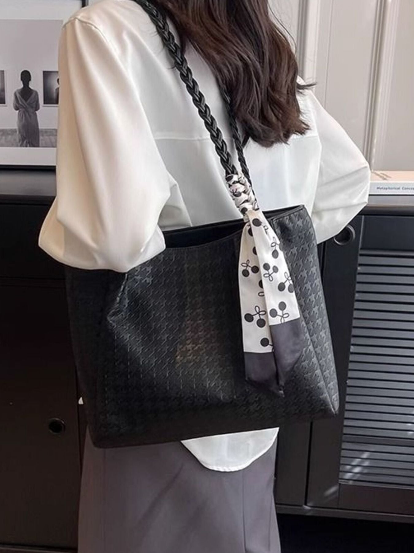 Black shopper bag with braided handle and patterned scarf detail