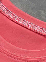 Coral t-shirt with white decorative stitching on the neckline and hem.