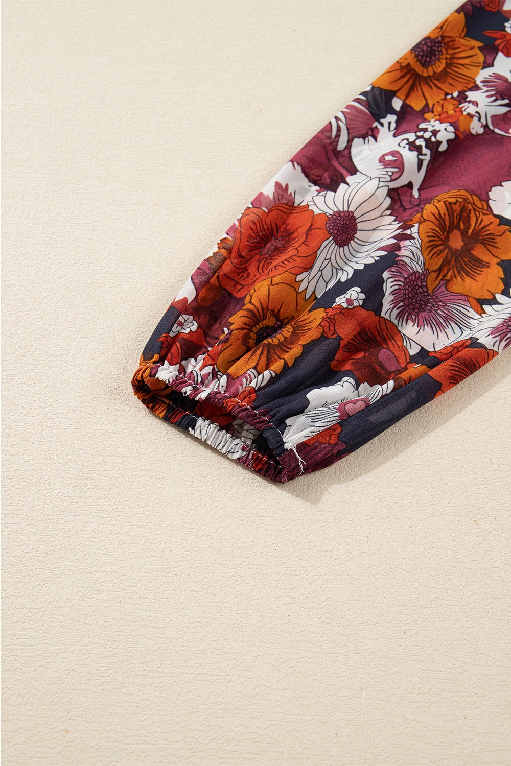 Floral wrap mini dress with puff sleeves and elastic cuff in navy with red and orange flowers