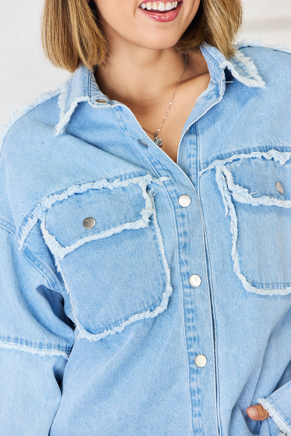 Light wash denim overshirt with frayed details and chest pockets.