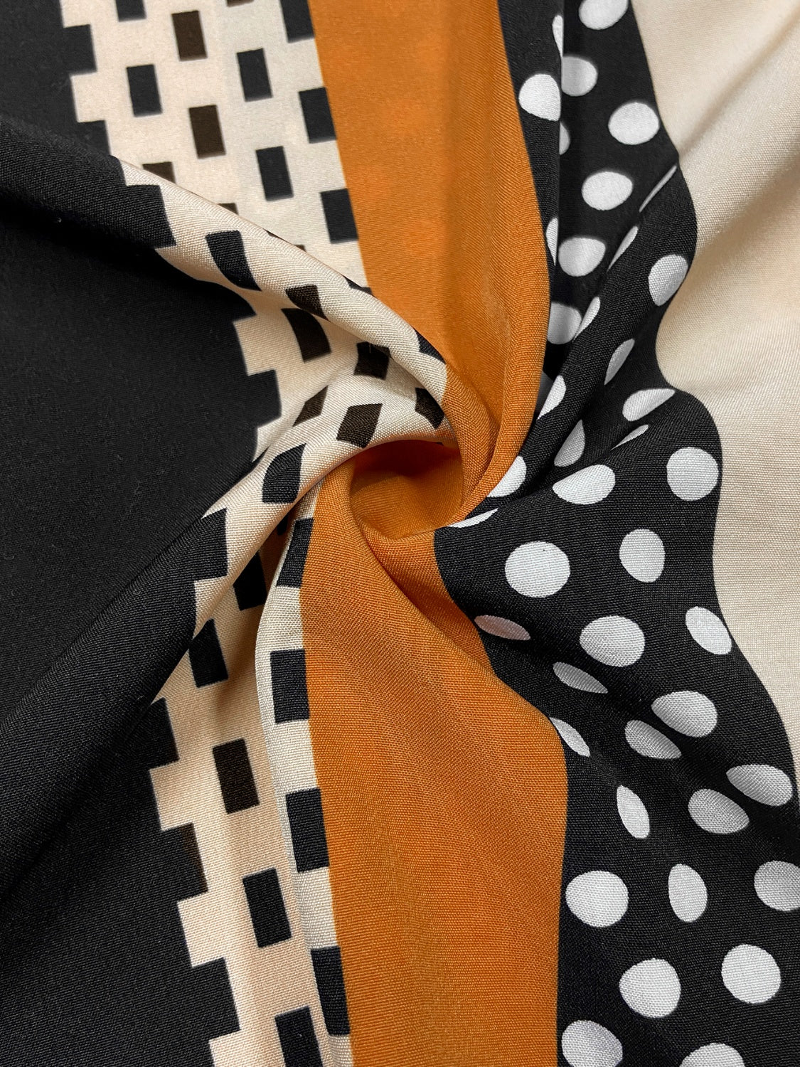 Black blouse with asymmetric stripe and polka dot pattern