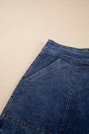 Denim wrap skort in medium blue with asymmetrical patch pockets and contrast stitching.